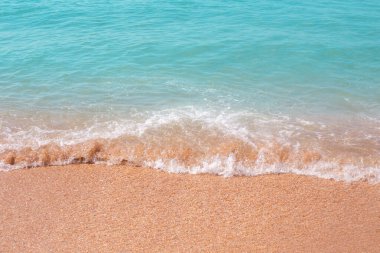 Deniz dalgası kumun üzerinde akıyor. Yaz tatili, seyahat ve turizm.