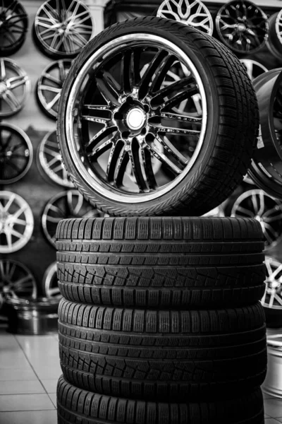 Uma pirâmide de pneus de borracha e rodas de liga. Compra e venda de novos pneus de inverno e verão — Fotografia de Stock