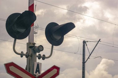 Demiryolu kavşağında trafik ışığı. Dikkatimizi çeken nesne, yolun ve demiryollarının kesiştiği yerde..