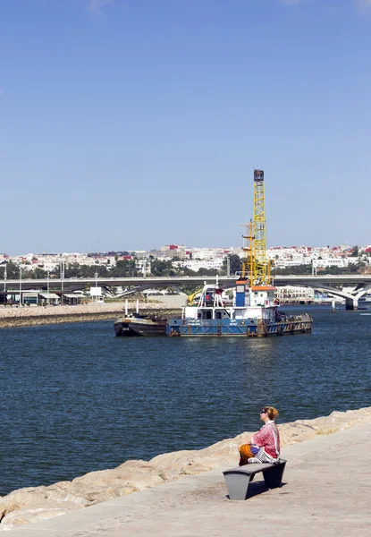 Donna seduta sulla riva del fiume — Foto Stock