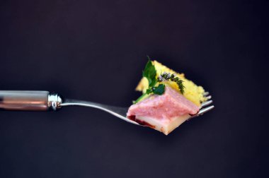 Çatallı, üzerinde nane ve pembe çilek kreması olan, siyah arka planda izole edilmiş lezzetli bir pasta.