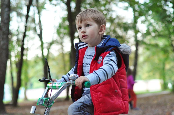 A boy rides a bicycle with admiring gaze — Stock Photo, Image