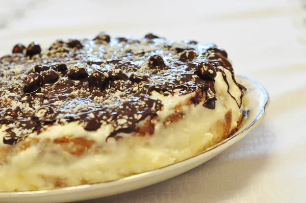 Κέικ σοκολάτας με ξηρούς καρπούς σε ένα πιάτο σε θολή φόντο — Φωτογραφία Αρχείου
