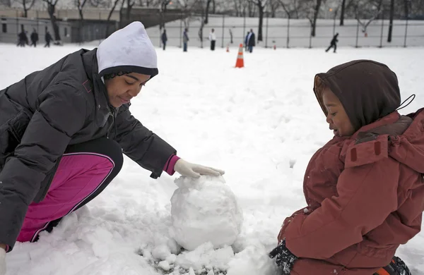 Mor med barn leker med snö — Stockfoto