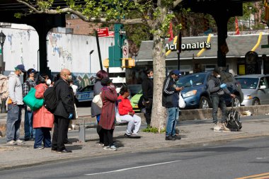 BRONX, NEW YORK, ABD - 18 Mayıs 2020: İnsanlar Covid-19 'a karşı koruyucu maskeler takarken durakta otobüs bekliyor.