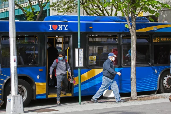 2020年5月18日 美国纽约州伯里克市 人们在与科维德的比赛中戴面具下城市巴士 图库图片
