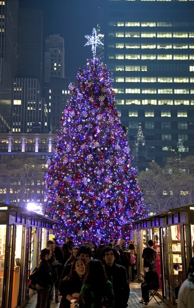 Människor i Bryant Park med julgranen i bakgrunden — Stockfoto