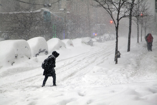 BRONX, NEW YORK - JANUARY 23: Woman crosses street during blizzard snow storm Jonas. Taken January 23, 2016, in the Bronx, New York.