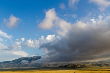 Alçak bulutlar dağlar önünde çölde