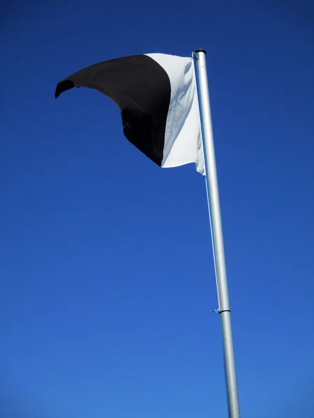 White and black flag flying f — Stock Photo, Image