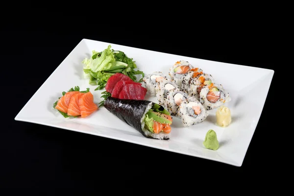 Sushi og sashimi med wasabi og grønnsaker i hvit tallerken – stockfoto