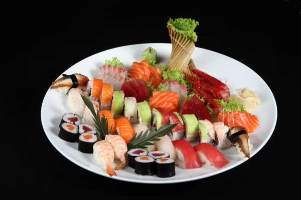 Sushi i sashimi mieszane na okrągły biały talerz — Zdjęcie stockowe