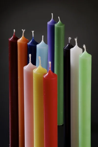 Grupp av färgglada cylindriska ljus g Stockbild