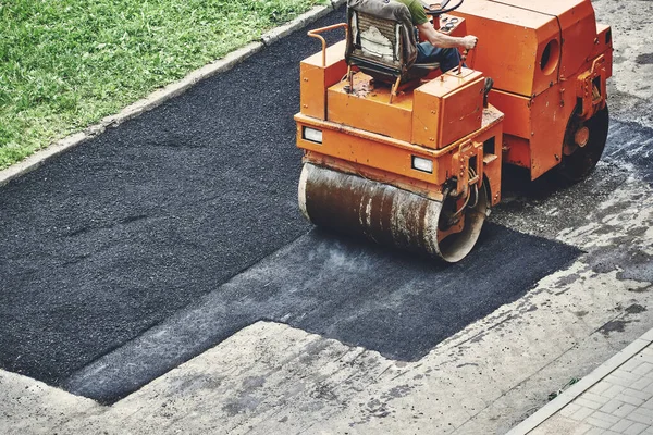 Road rollers are laying hot asphalt