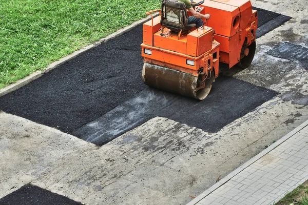 Road rollers are laying hot asphalt