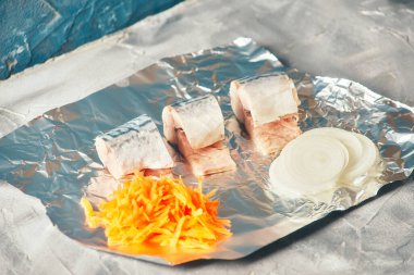 Pişirmek için folyonun üzerinde taze doğranmış havuç balığı var. sağlıklı beslenme