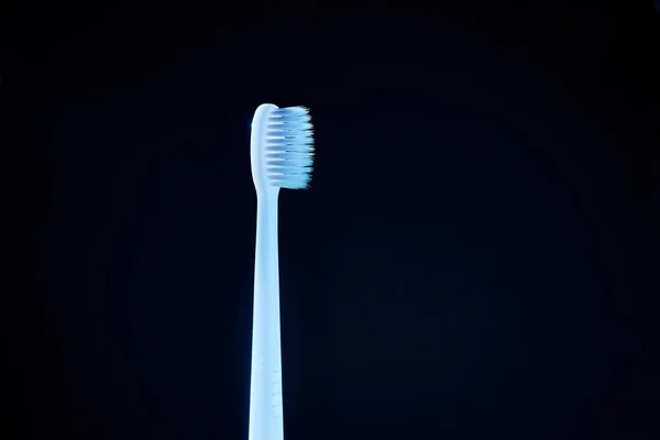 Biała Szczoteczka Zębów Niebieskim Świetle Ciemne Tło — Zdjęcie stockowe