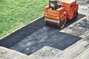 Yol silindirleri sıcak asfalt seriyor.