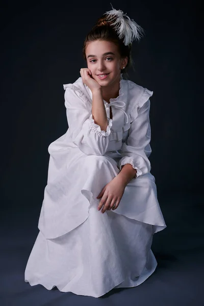 Beyaz elbiseli genç bir kızın eski moda bir portresi. Stüdyo. koyu arkaplan