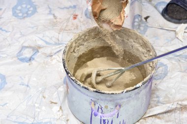 Tencerede çimento harcı yoğuruyorum. Onarım için hazırlık