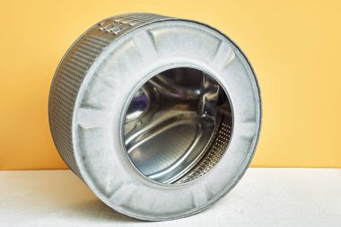 Metal varil çamaşır makinesi. Çamaşır makinesini tamir eder. Sarı arkaplan