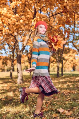 Sarı turuncu yapraklı genç bir kızın sonbahar portresi.