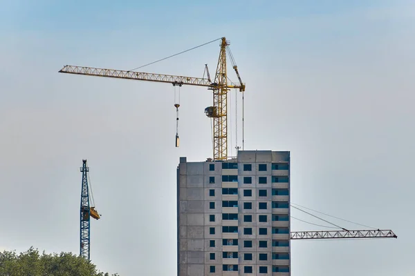 large construction crane builds high-rise building