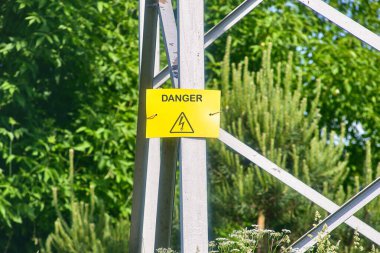 Demir elektrik direğindeki sarı tabela tehlikesi