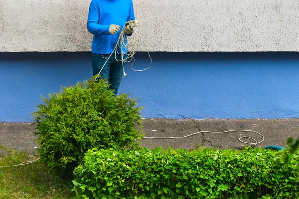 İşçi elinde bir uzatma kablosu tutuyor.