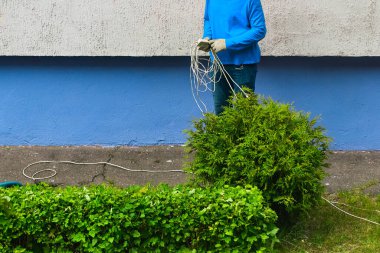 İşçi elinde bir uzatma kablosu tutuyor.