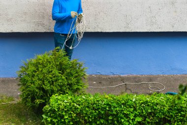 İşçi elinde bir uzatma kablosu tutuyor.