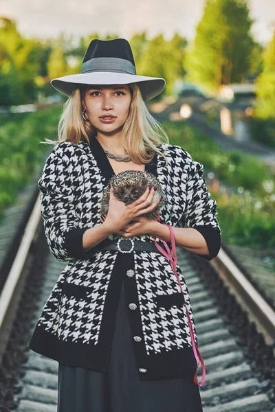 Sarışın Şapkalı Kız Demiryolunun Yanında Elinde Kirpi Tasması Tutuyor — Stok fotoğraf