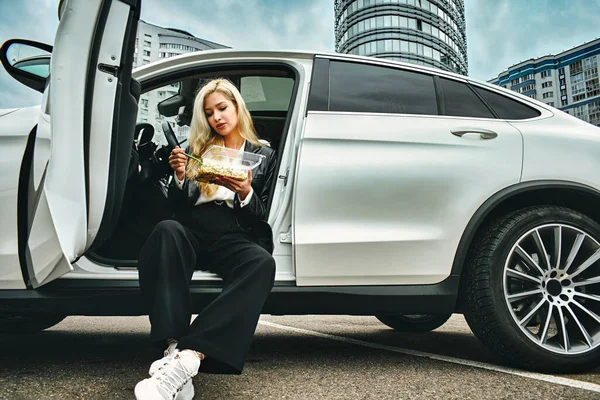 business lunch in the car. girl eating fast food on the road