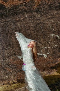 Moda yaratıcı. Plastik şişelerle selofanda poz veren bir model. konsept