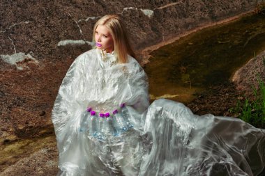 Moda yaratıcı. Plastik şişelerle selofanda poz veren bir model. konsept