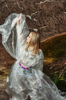 Moda yaratıcı. Plastik şişelerle selofanda poz veren bir model. konsept