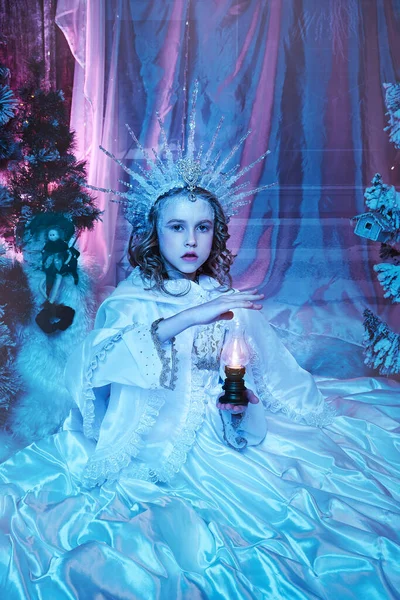 snow fairy in the forest holds a lamp with fire in her hands. fabulous decoration