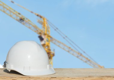 bina inşaat ile ahşap masa üzerinde güvenlik kask ve mimar bitki