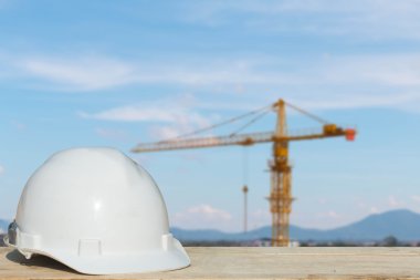 bina inşaat ile ahşap masa üzerinde güvenlik kask ve mimar bitki