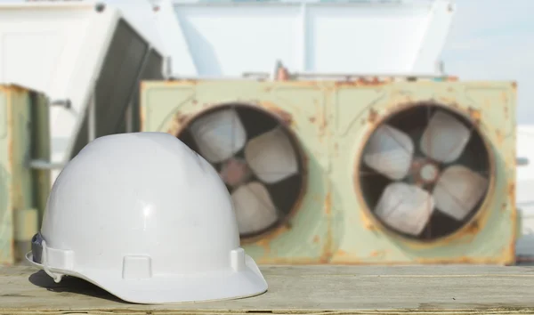 Ingeniería de seguridad y casco que descansa en los detalles de los compresores de refrigeración . — Foto de Stock