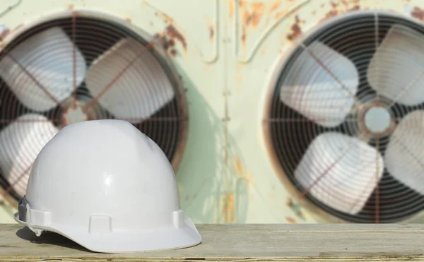Veiligheidstechniek en een helm die rusten op de details van koeling compressoren. — Stockfoto