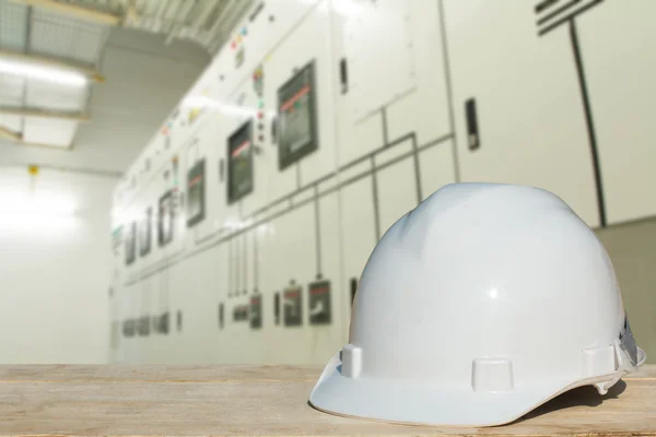 La ingeniería y un casco para la seguridad se enfrenta a interruptores eléctricos - industria de paneles eléctricos de conmutación . — Foto de Stock