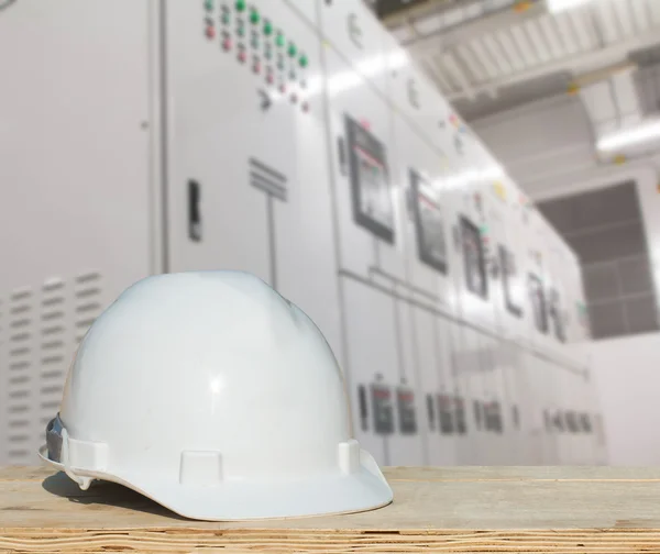 La ingeniería y un casco para la seguridad se enfrenta a interruptores eléctricos - industria de paneles eléctricos de conmutación . — Foto de Stock