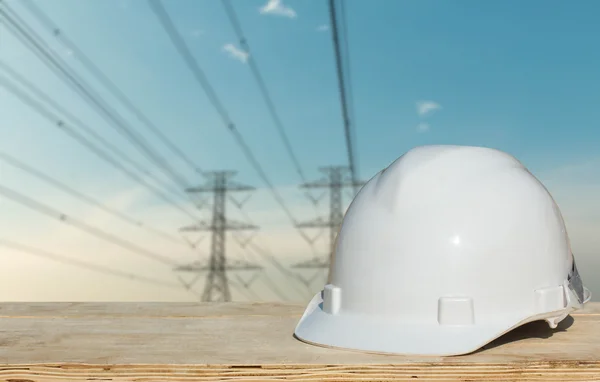 Cascos blancos para la seguridad de las personas en el fondo. Polo de alto voltaje — Foto de Stock