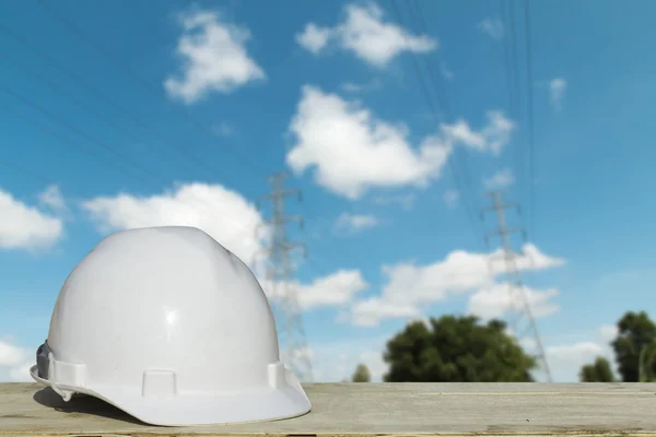 Witte helmen voor de veiligheid van mensen op de achtergrond. Hoogspanning pole — Stockfoto