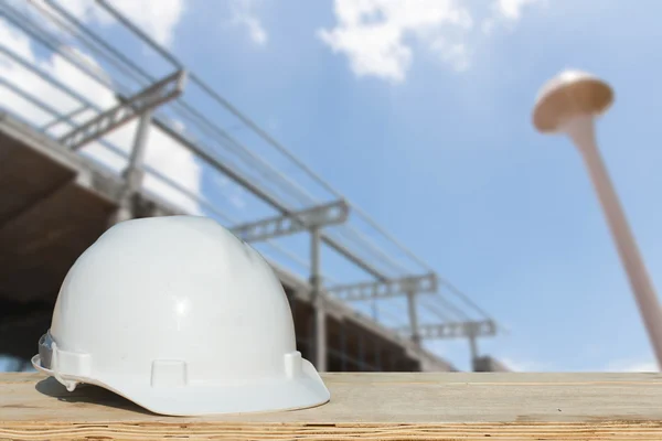 Защитный шлем и архитектурный завод на деревянном столе со строительством — стоковое фото