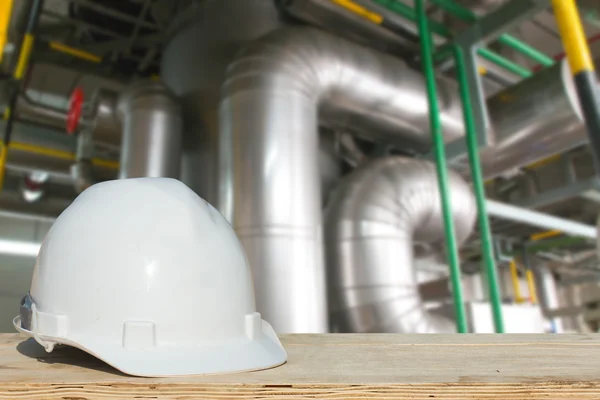 Safety engineering and a helmet resting on the details of refrigeration compressors.