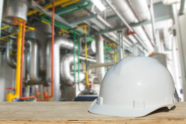 Safety engineering and a helmet resting on the details of refrigeration compressors.