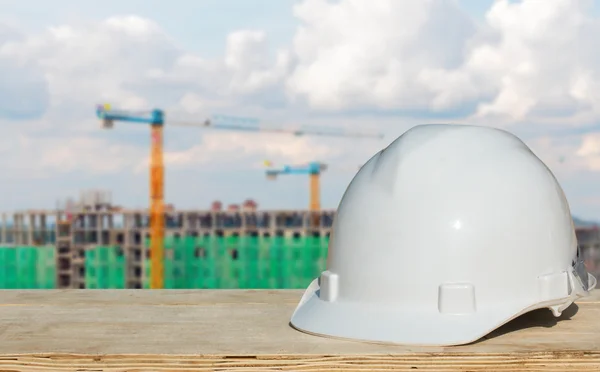 Veiligheid helm en architect plant op houten tafel met bouw — Stockfoto