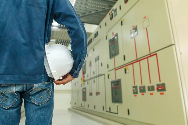Ingeniero de casco en la industria eléctrica del interruptor del panel trasero . — Foto de Stock